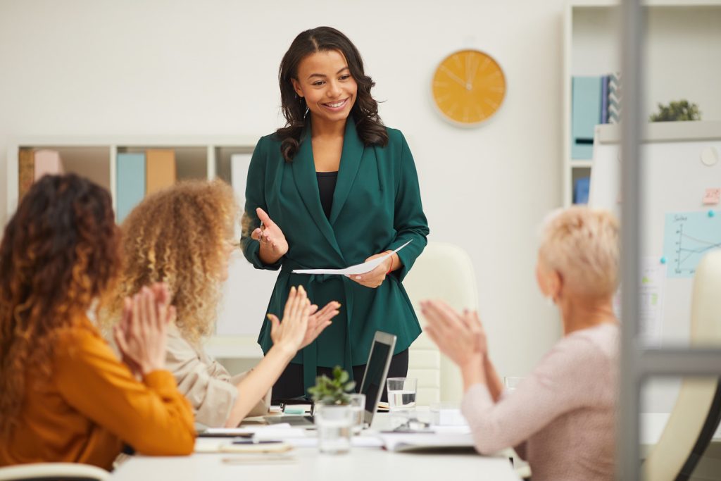 Charming African American Woman Finishing Presentation At Meeting Her Colleagues Clapping Hands